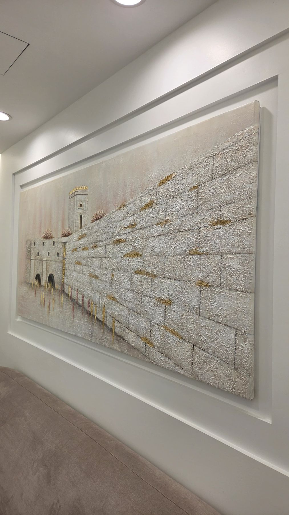 White relief painting in a hallway, matched to the client's couches